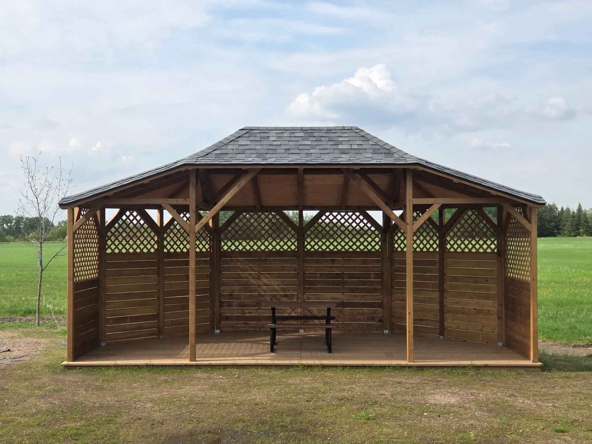 The gazebo in daylight, showing the roof, the lattice sides and the cedar deck