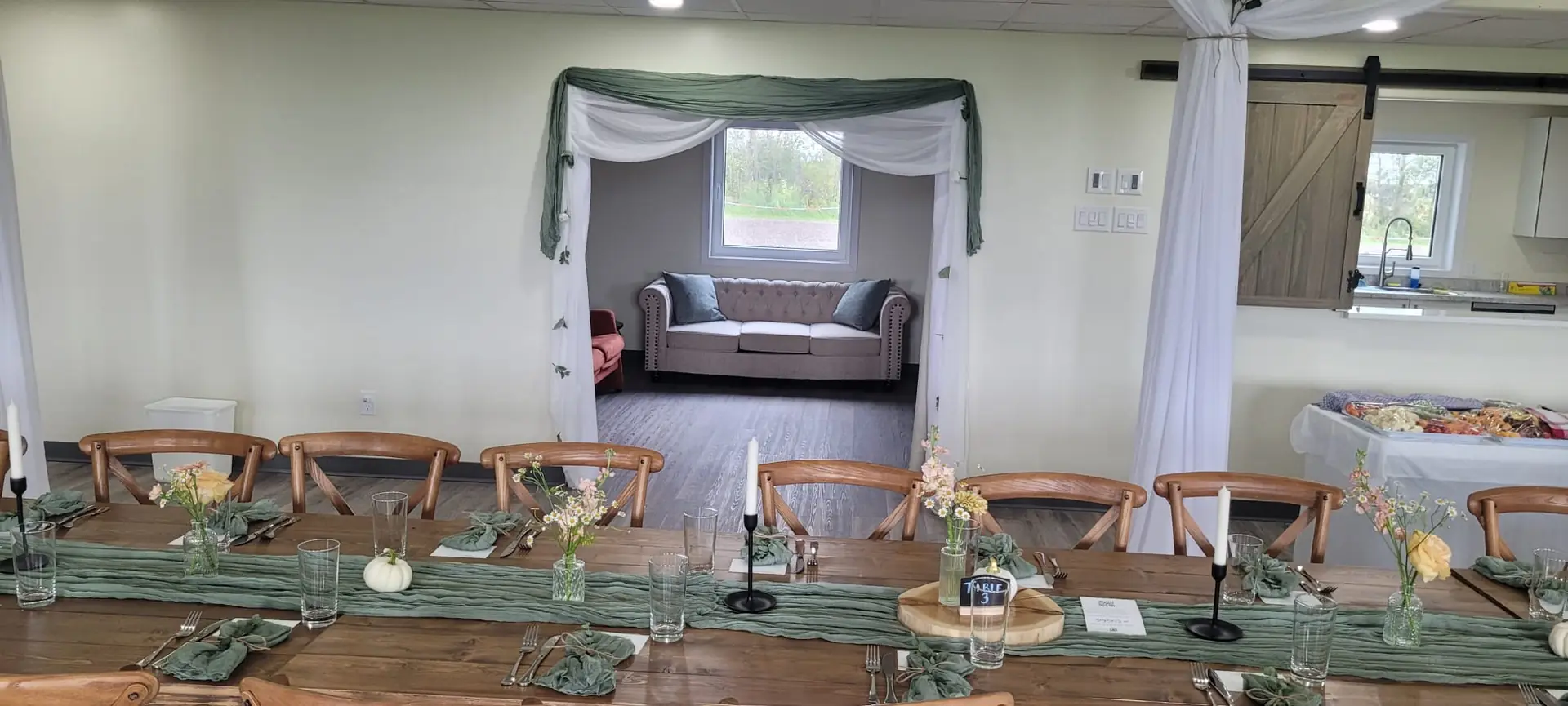 The full length of the hall at Bristol Event Centre, set with round tables and a draped vaulted ceiling